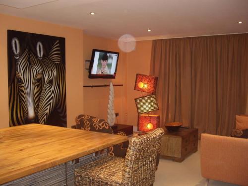 a living room with a painting of zebras on the wall at Portland Apartments in Cheltenham