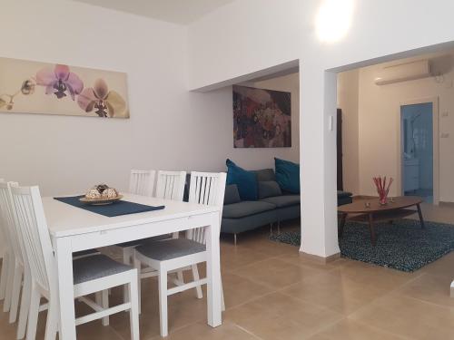 a living room with a white table and chairs at אבני החושן- Avnei Hoshen in Nahariyya