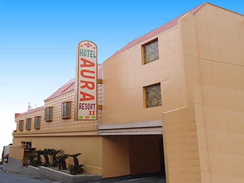a building with a sign on the side of it at Hotel Aura Resort Ⅱ Kashiba (Adult Only) in Nara
