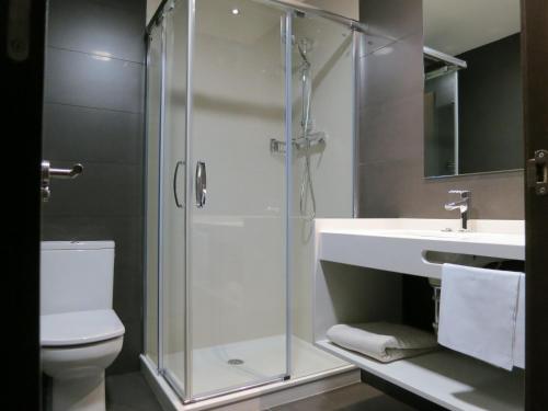 a bathroom with a shower and a toilet and a sink at Apartamentos Clarín in Oviedo