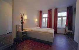 una camera con un letto e due finestre di Ab ins Postkutscherl a Würzburg