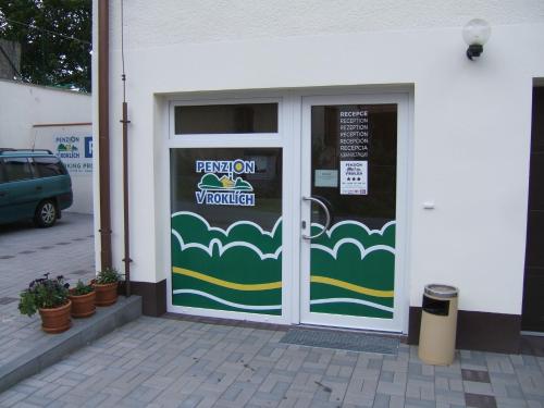 a door to a building with a sign on it at Penzion V Roklich & Apartmens V Roklich in Ricany