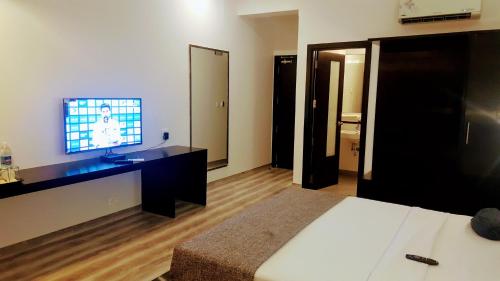 a bedroom with a bed and a flat screen tv at The Saneer Jaipur in Jaipur