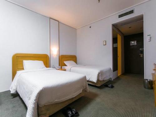 Ένα ή περισσότερα κρεβάτια σε δωμάτιο στο Busan Tourist Hotel