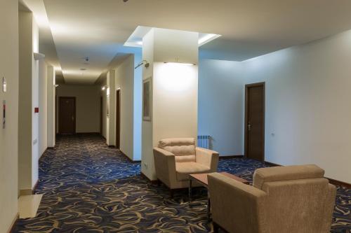 a hallway with two chairs and a waiting room at Armenia Hotel in Jermuk
