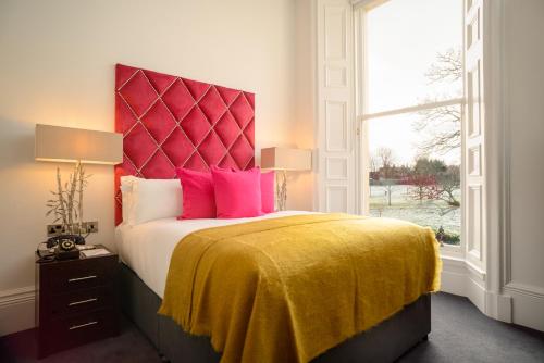 a bedroom with a bed with a yellow blanket and a window at Black Ivy in Edinburgh