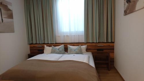 a bedroom with a large bed with a window at Alpinlounge Rätia Appartements in Ischgl