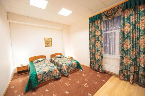1 dormitorio con 2 camas y ventana en Hotel Orion, en Surgut