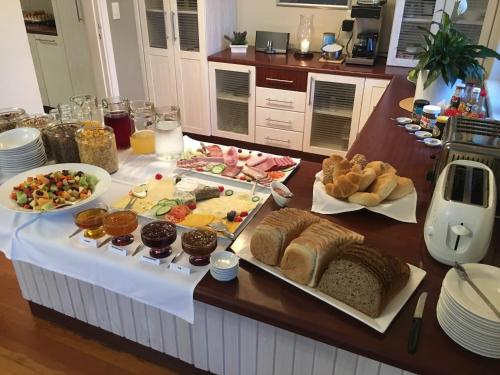 uma mesa com muitos tipos diferentes de pães e doces em Cornerstone Guesthouse em Swakopmund