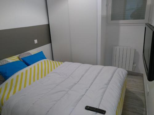 a bedroom with a bed with a remote control on it at Plaisance du Touch in Plaisance-du-Touch