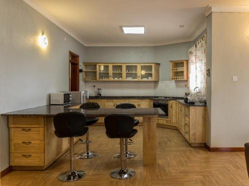 a kitchen with a counter and two bar stools at Ibis Apartments in Kampala