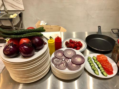 a table with plates of vegetables and a cake at Lemongo Youth Hostel Hohhot in Hohhot