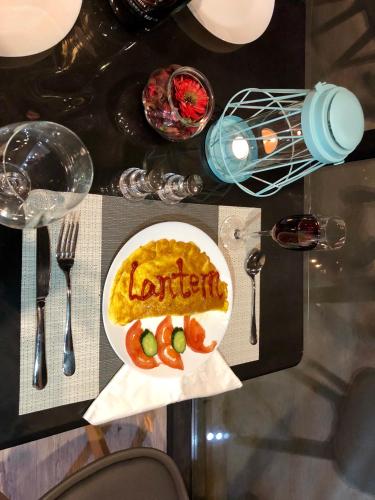 a table with a plate of food on a table at Lemongo Youth Hostel Hohhot in Hohhot