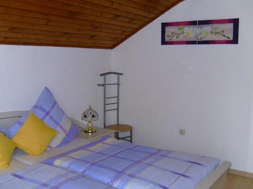 グラフェナウにあるFerienwohnung Pinkerのベッドルーム1室(紫と黄色の枕が備わるベッド1台付)