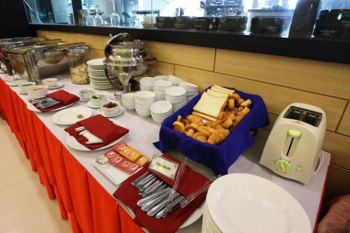 a table with cheese and other food on it at Coins Hotel Jakarta in Jakarta