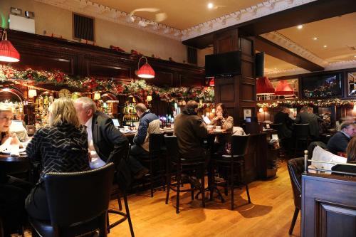 a group of people sitting at tables in a restaurant at Grand Hotel Tralee in Tralee