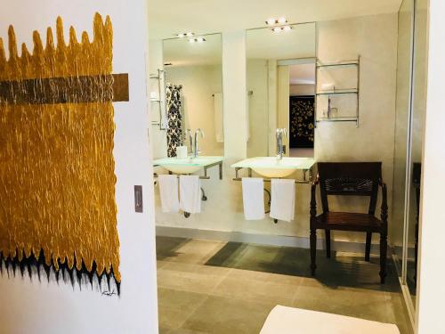a bathroom with two sinks and a chair and a mirror at Baipho Lifestyle in Patong Beach