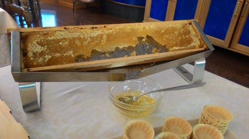a beehive being used to make a container of honey at Hotel Migliorati in Castione della Presolana