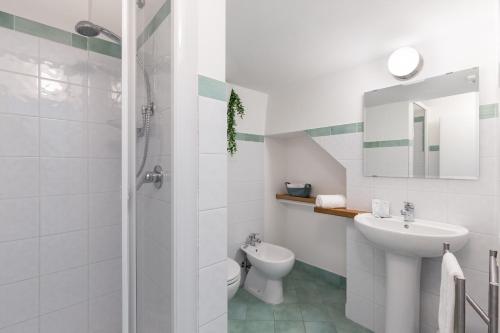 a white bathroom with a sink and a toilet at La rosa dei venti in Gaeta