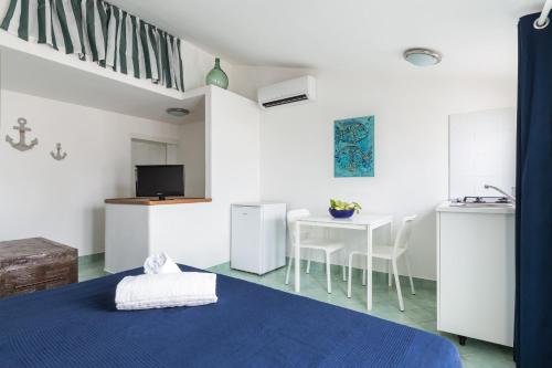 a white room with a blue bed and a table at La rosa dei venti in Gaeta