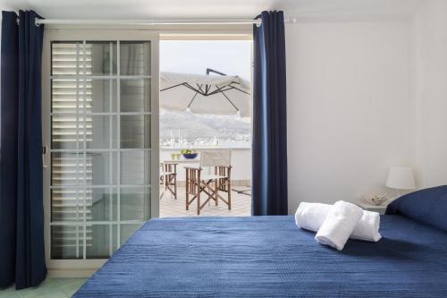 a bedroom with a blue bed and a view of a patio at La rosa dei venti in Gaeta