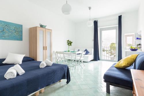 a living room with two beds and a table and chairs at La rosa dei venti in Gaeta