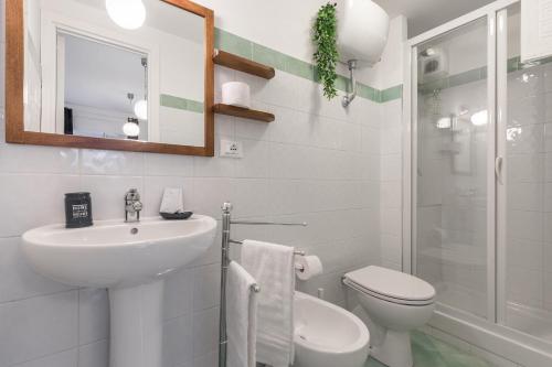 uma casa de banho com um lavatório, um WC e um espelho. em La rosa dei venti em Gaeta