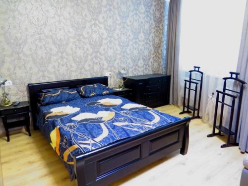 een slaapkamer met een bed met een blauw dekbed bij Apartment on Svobodu ave in Sumy