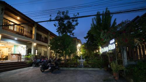 a group of motorcycles parked outside a building at night at Buathong Place in Lamai