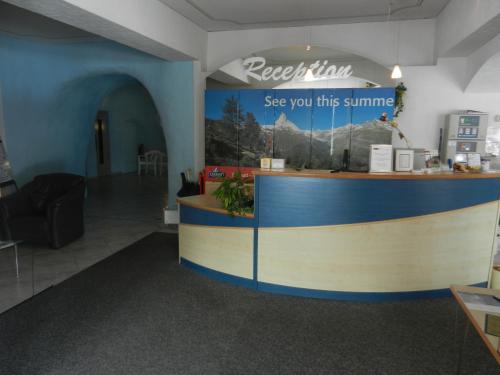 a restaurant with a counter with a sign that reads see you this summer at Artist Apartments & Hotel Garni in Zermatt