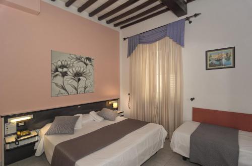 Hotel Amalfitana tesisinde bir odada yatak veya yataklar