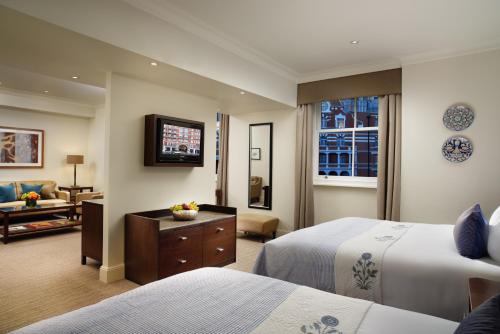 a hotel room with two beds and a living room at St. James' Court, A Taj Hotel, London in London