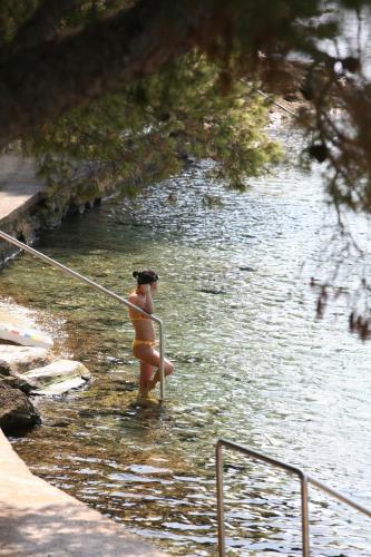 a woman in a bikini standing in the water at Hotel Sali in Sali
