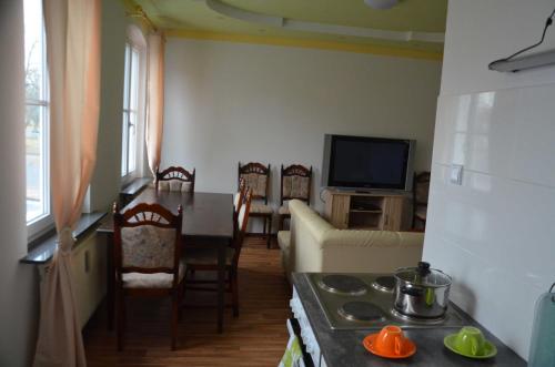 a kitchen and living room with a table and a television at LEKOMA Pension in Niedergörsdorf