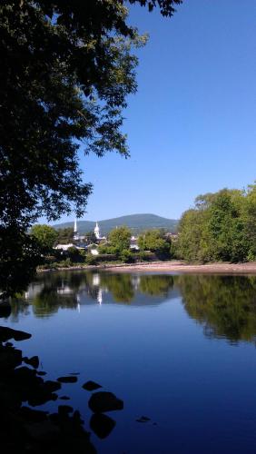 a lake with trees and a building in the background at Gîte TerreCiel in Baie-Saint-Paul