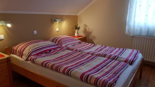 a bedroom with two beds with striped blankets at Laci Apartman in Zalakaros