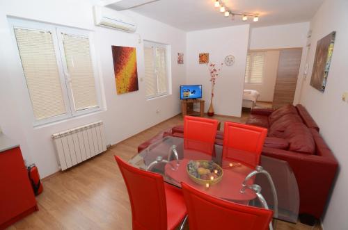 a living room with a couch and a table and red chairs at Maritimo Apartments in Kotor