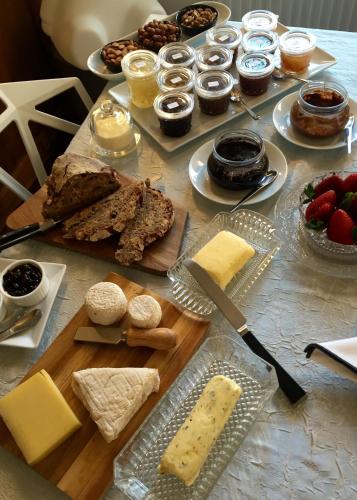 a table with cheese and other foods on it at Quai 17 Maison d'hôtes in Strasbourg