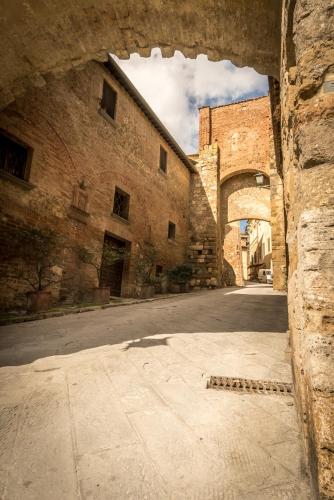 an alley in an old stone building with an archway at Porta delle Farine in Montepulciano