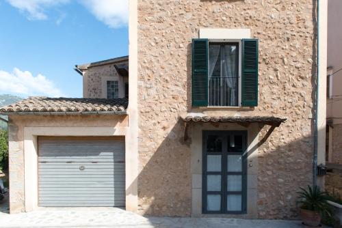 a building with a garage door and a window at Cal Tio Lluc in Sóller