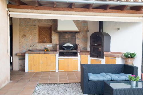 a kitchen with a stove and a couch in a kitchen at Cal Tio Lluc in Sóller