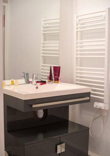 une salle de bain avec un lavabo blanc et un miroir dans l'établissement Goélia Les 7 Iles, à Perros-Guirec