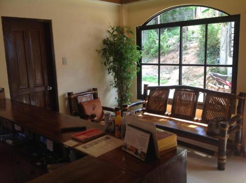 a dining room with a table and a large window at Divine Castle Travelers Inn in Coron