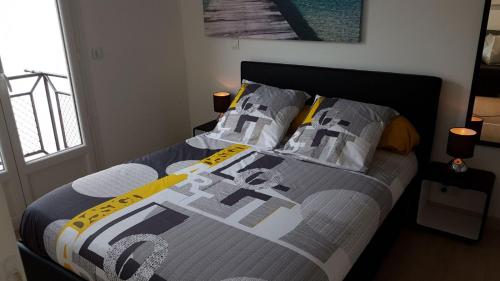 Una cama con un edredón y almohadas encima en Nice Apartment in Menton French Riviera, en Menton