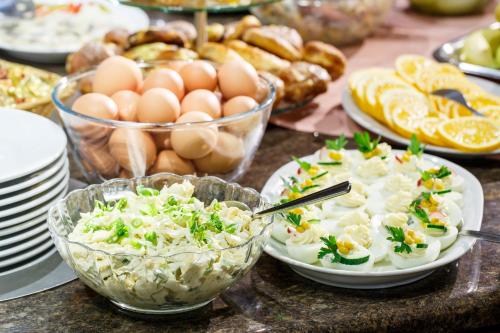 a table topped with bowls of food and eggs at Hotel City SM Business & Spa in Kraków