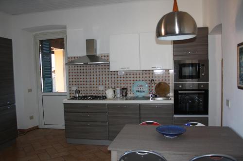 a kitchen with white cabinets and a table in it at Casa Lawrence in Brisino