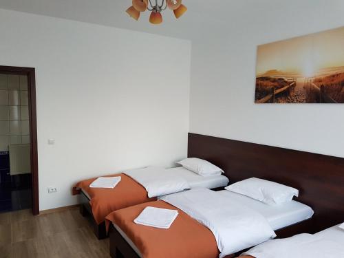 Habitación con 3 camas y ventilador de techo. en Pension Yasmine, en Timisoara