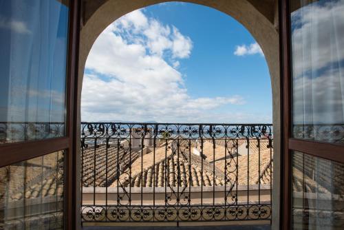 an open window with a view of a hill from a balcony at Residenze al Castello Apartments in Cagliari