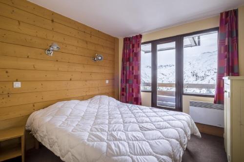 une chambre avec un lit et un mur en bois dans l'établissement Residence Aster - maeva Home, à Avoriaz