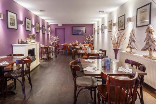 um restaurante com mesas e cadeiras de madeira e paredes roxas em Hotel Santa Maria em Roterdã